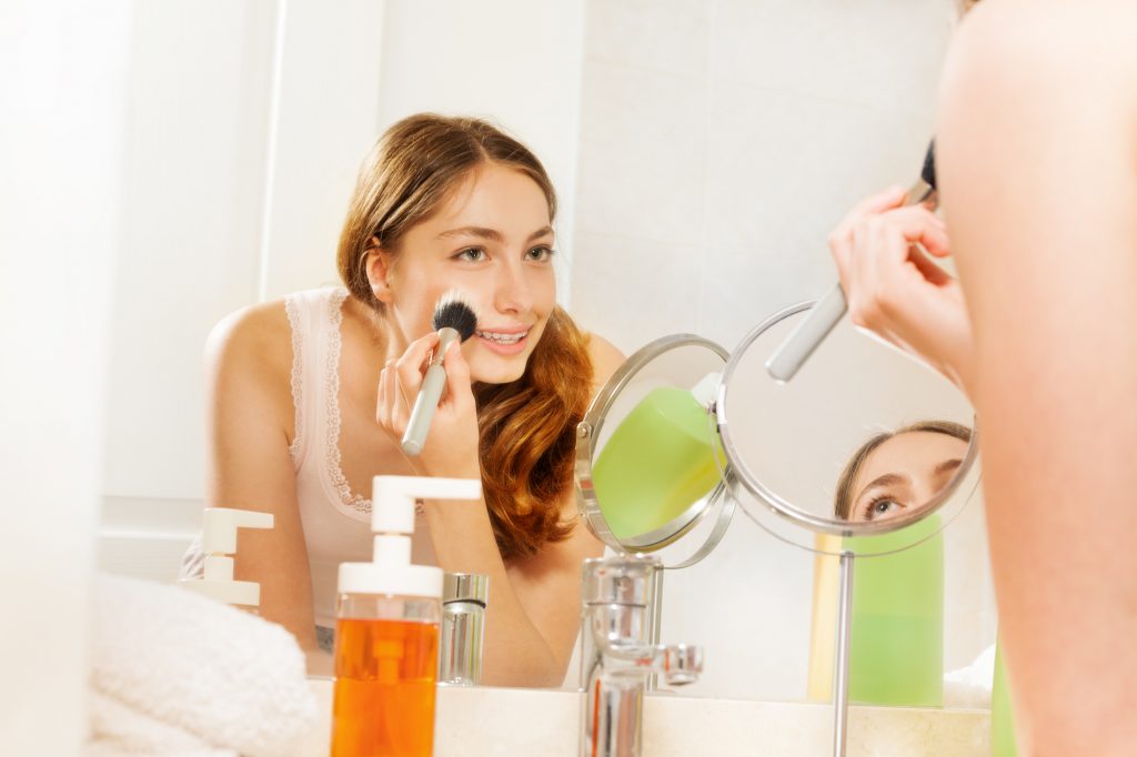 Woman looking in the mirror pampering herself