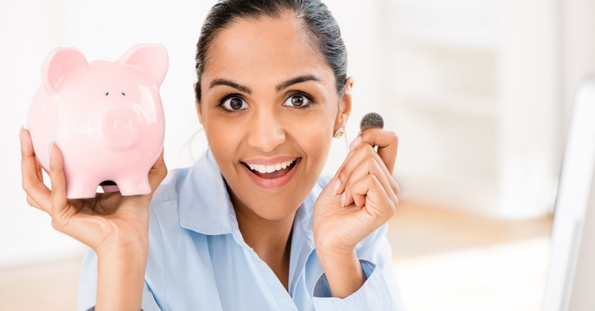 woman smiling to save money in piggy bank