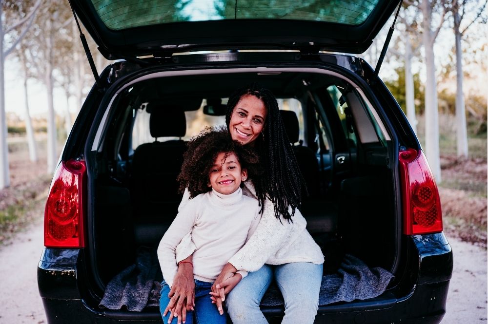 Single mom with kids in back of new car